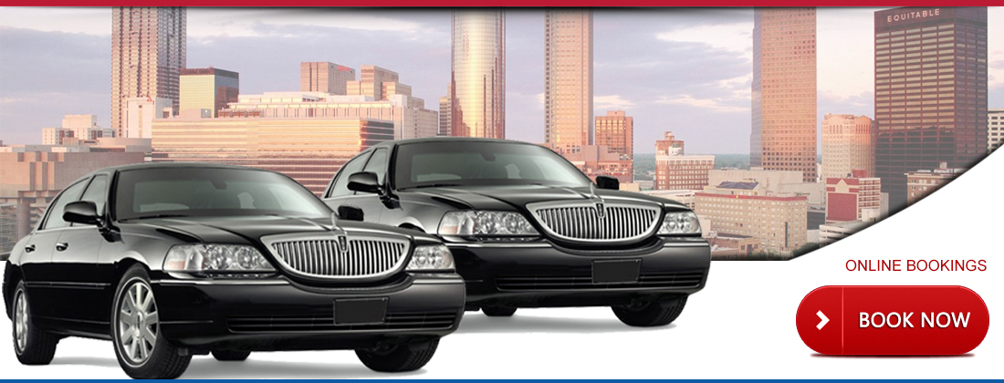 Two black Lincoln Town Car sedans in front of the Atlanta skyline